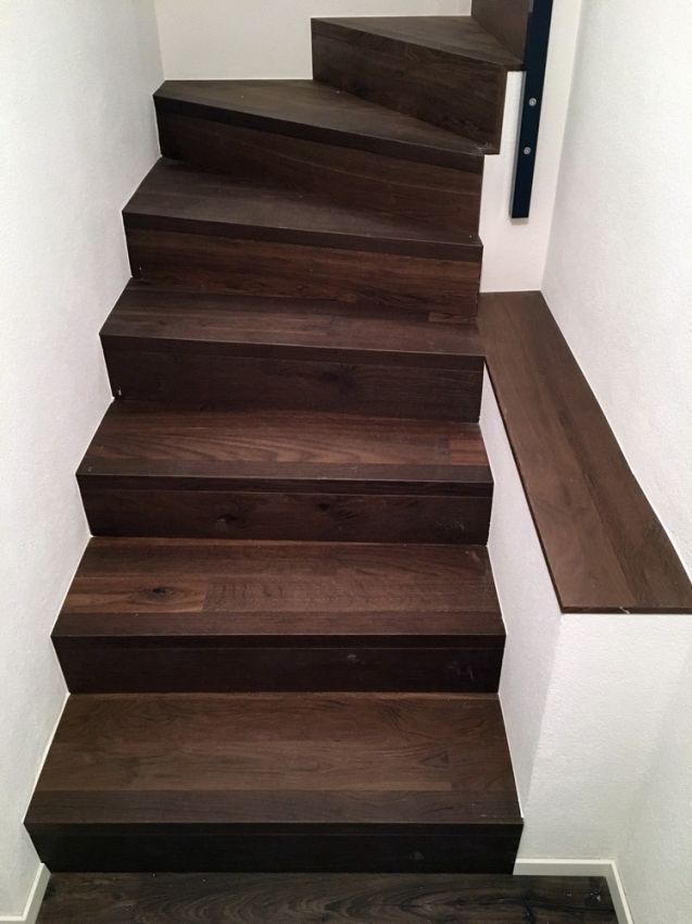 un escalier en bois avec un garde-corps en métal noir