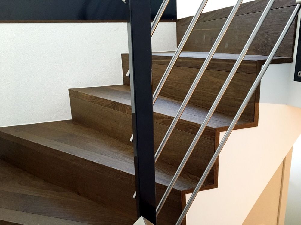 un escalier en bois avec une main courante en acier inoxydable