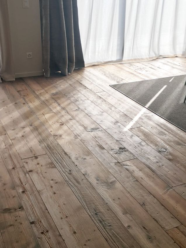 un sol en bois dans une pièce avec des rideaux blancs