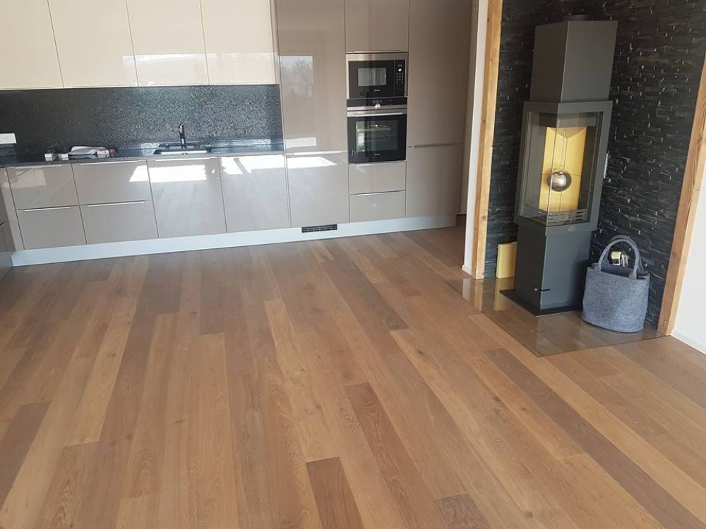 une cuisine avec un plancher en bois et un four en acier inoxydable