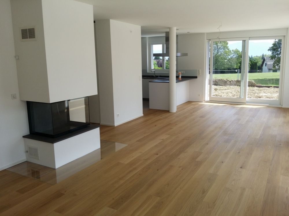 un salon avec un plancher en bois et une cheminée