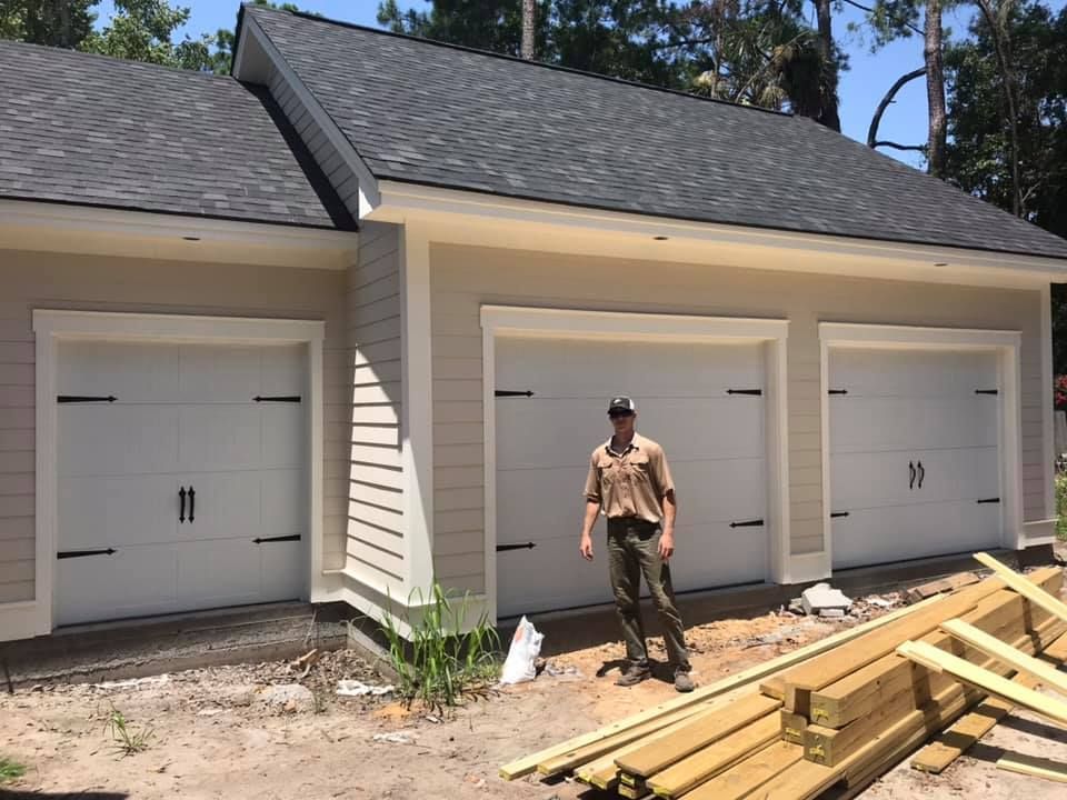 A man standing in front of a garage with the number 19 on it