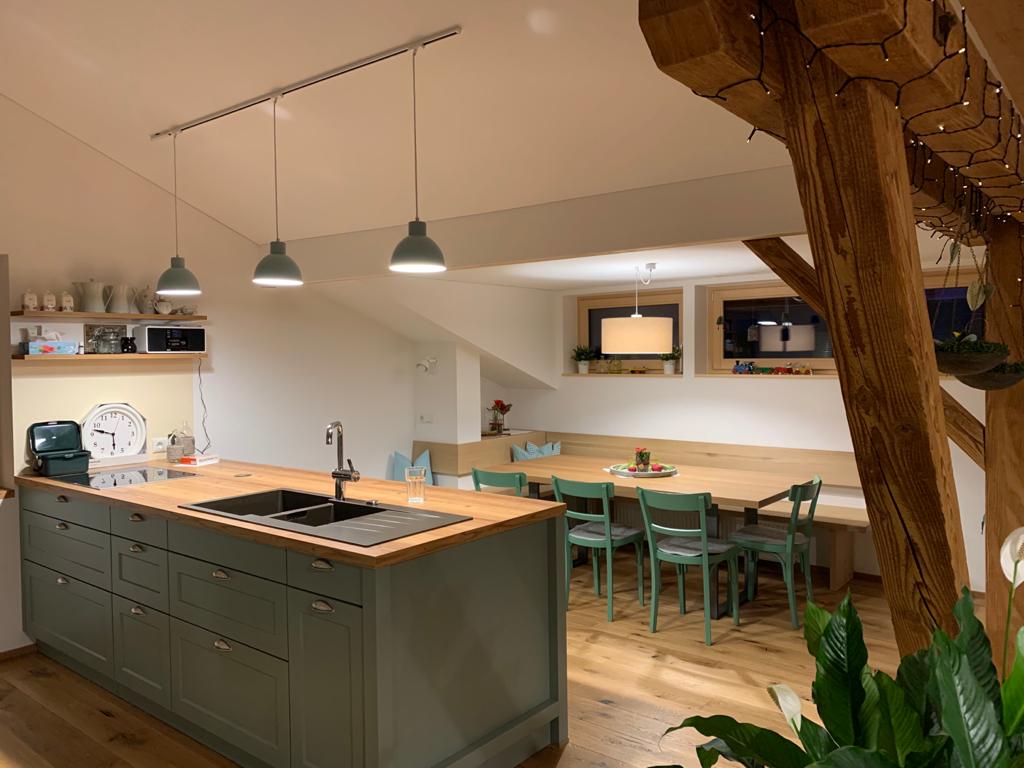 Eine Küche mit großer Kochinsel, Spüle, Tisch und Stühlen.