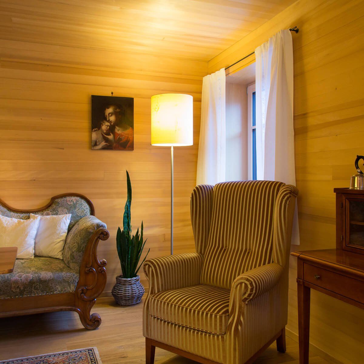 Ein Wohnzimmer mit einer Couch, einem Sessel und einer Lampe