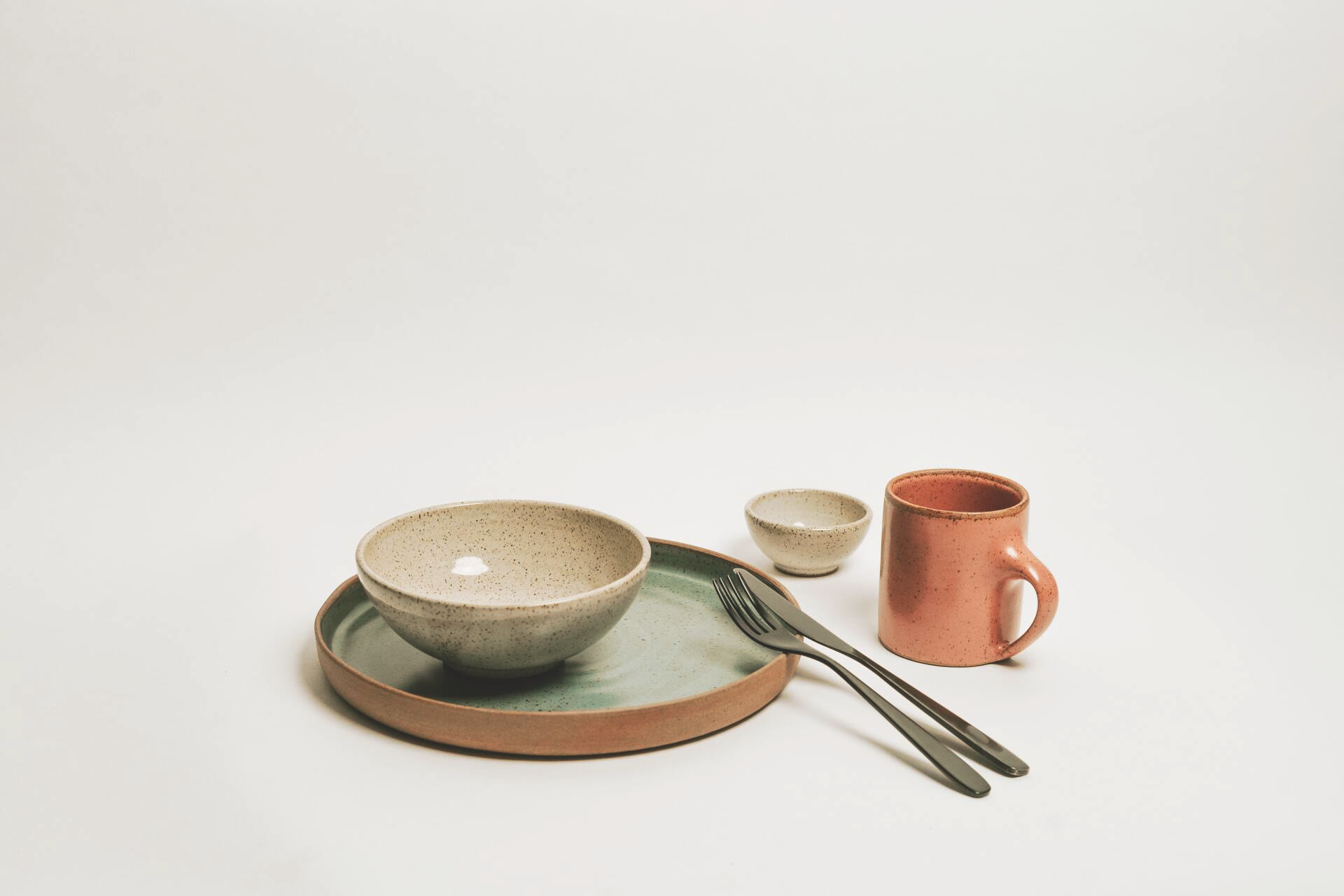 Ceramic dinnerware in neutrals with a caption that says 