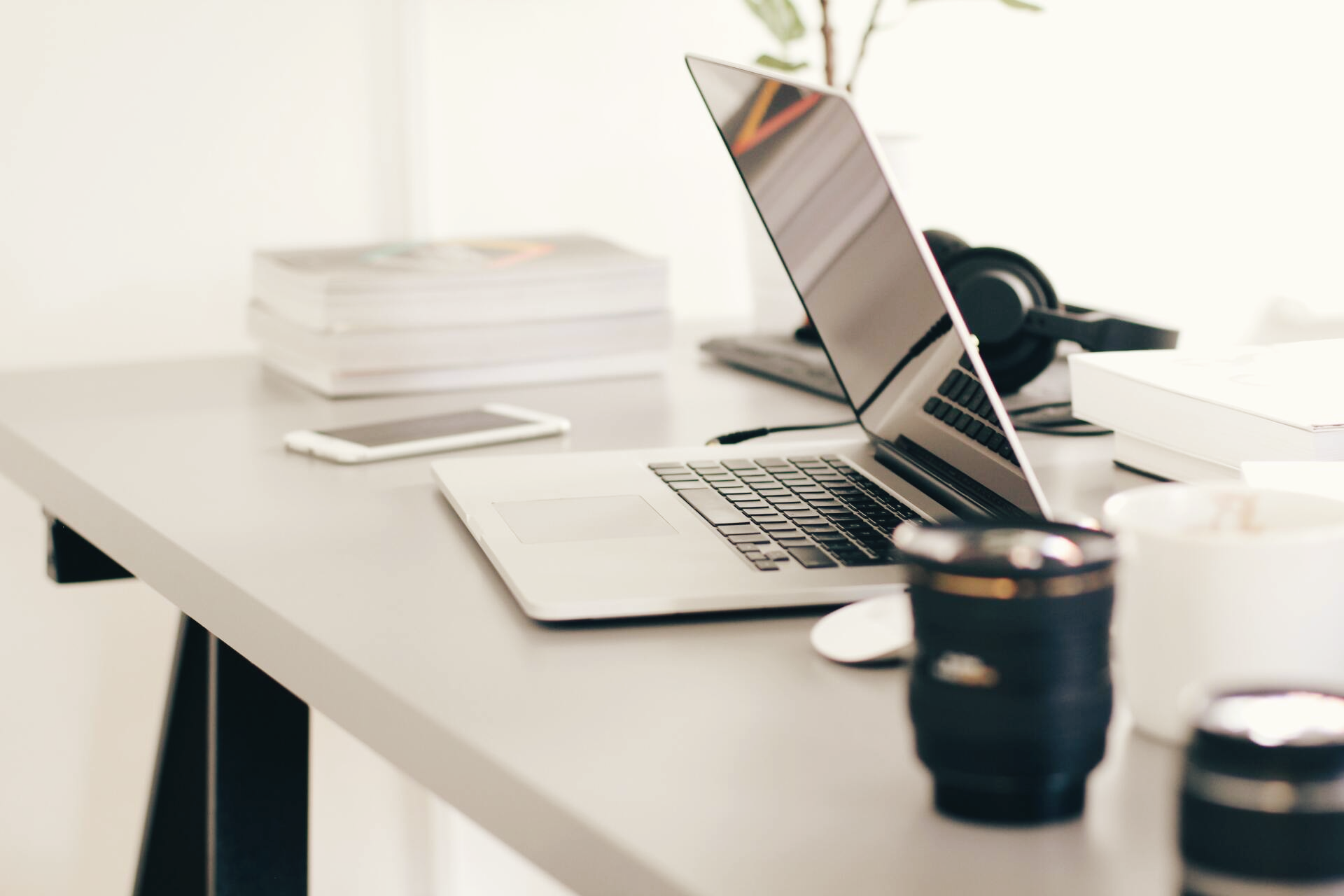 A modern desk with laptop and coffee mug with a caption that says 