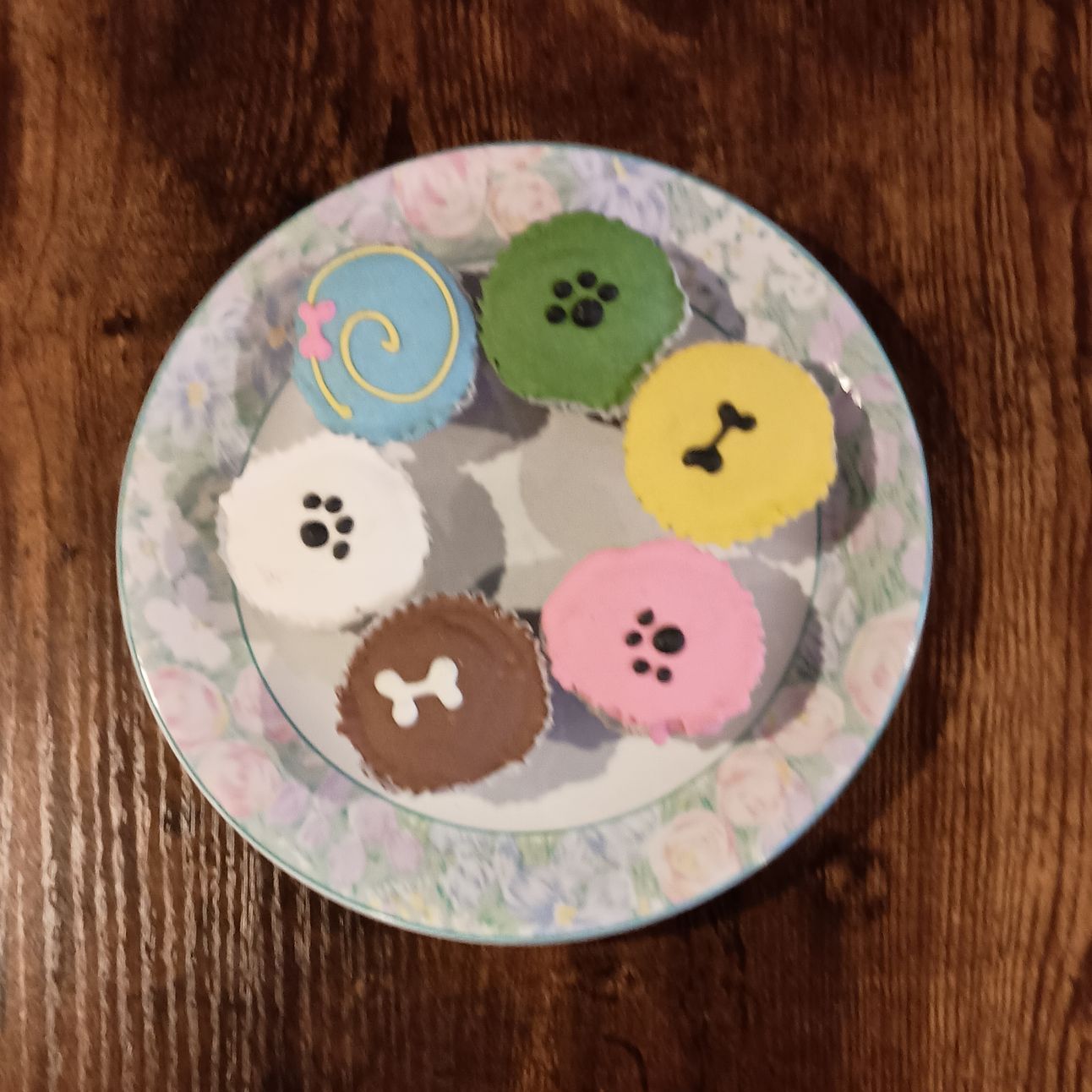 Colorful dog Cupcakes with paw and bone icing designs served at Smokey's Doggy Cafe.