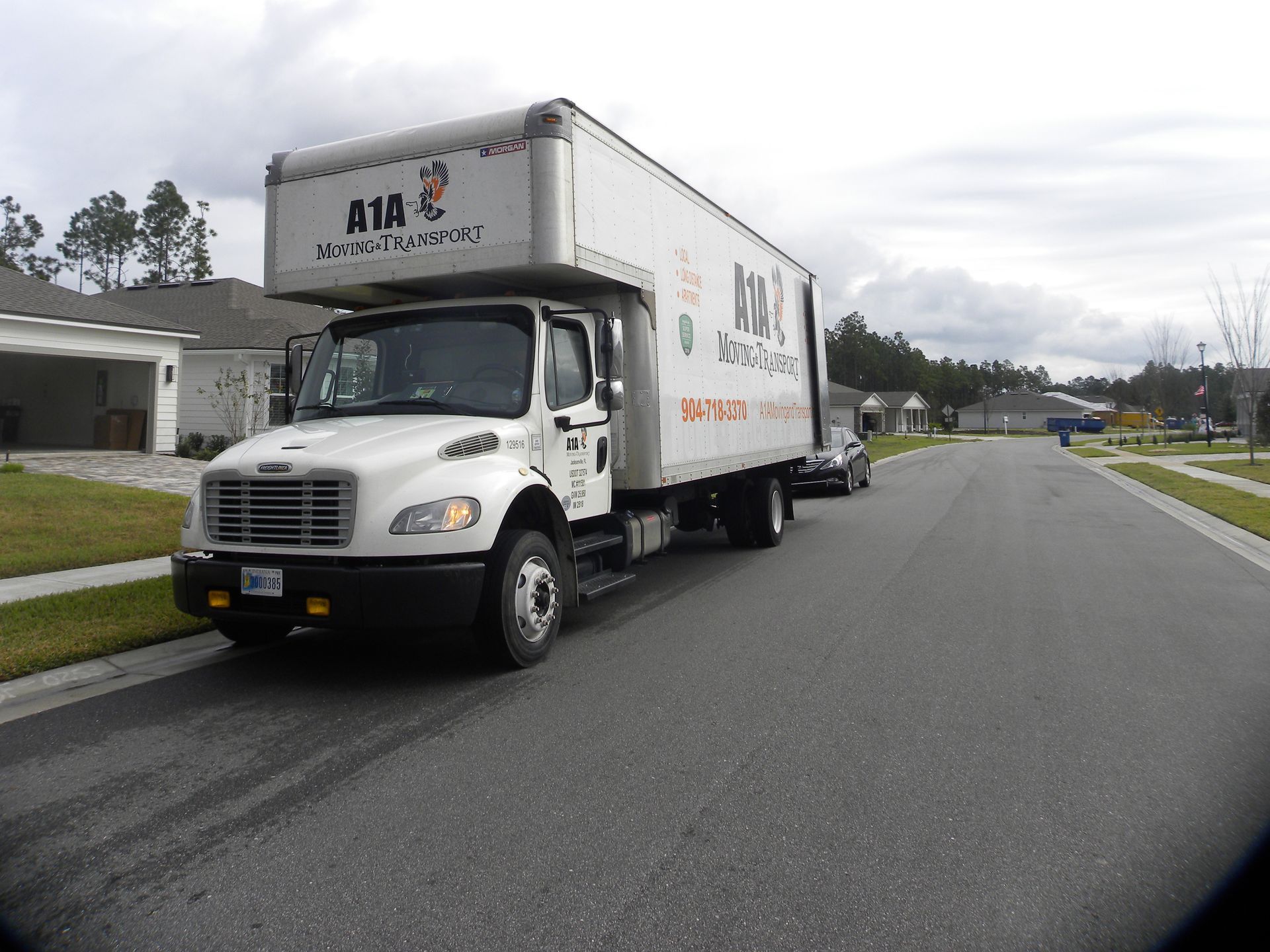 Sandblasting and Rust Removal in Harford County, MD Three people loading a large, wrapped item onto a moving truck in a residential street.