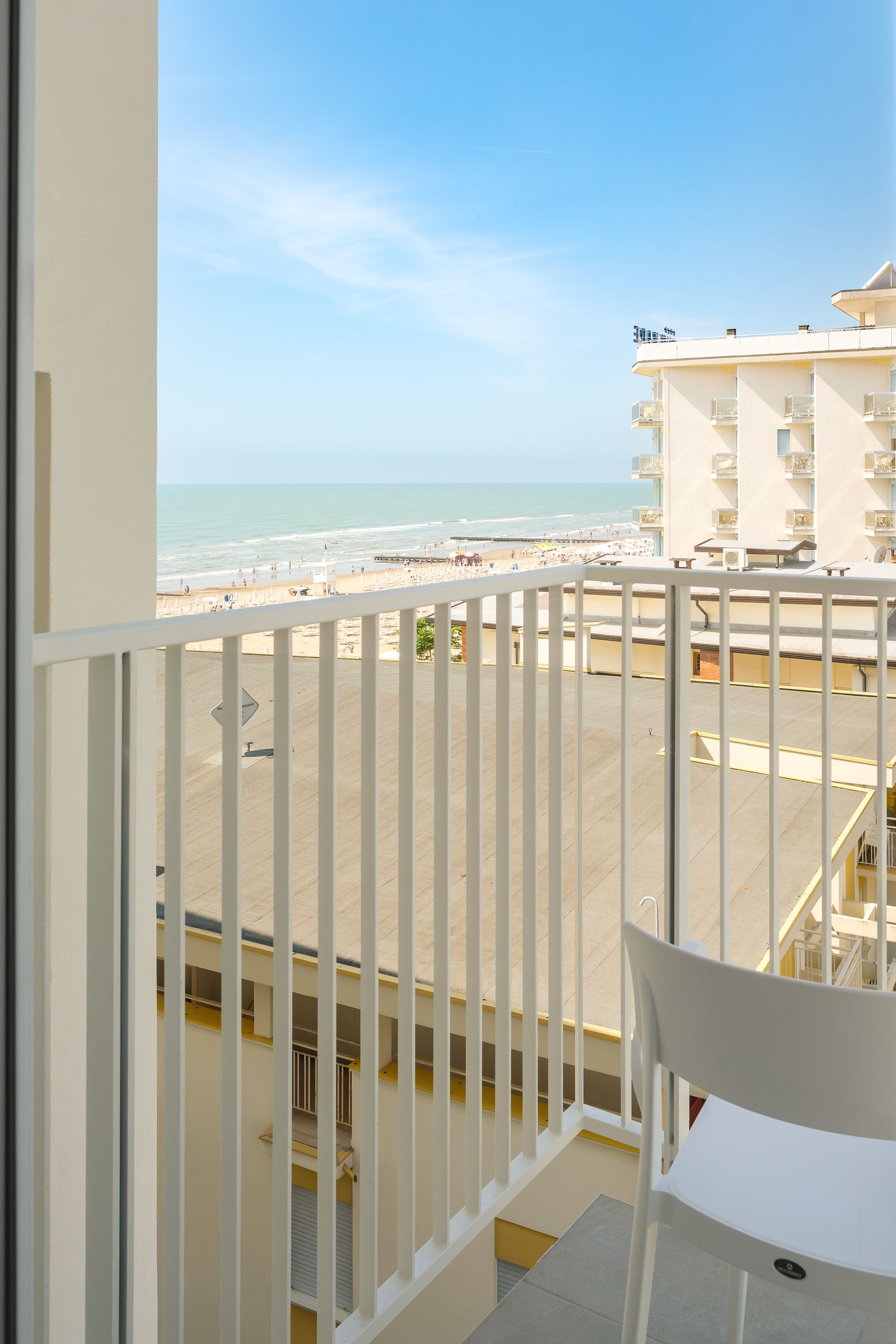 A balcony with a view of the sea and buildings.