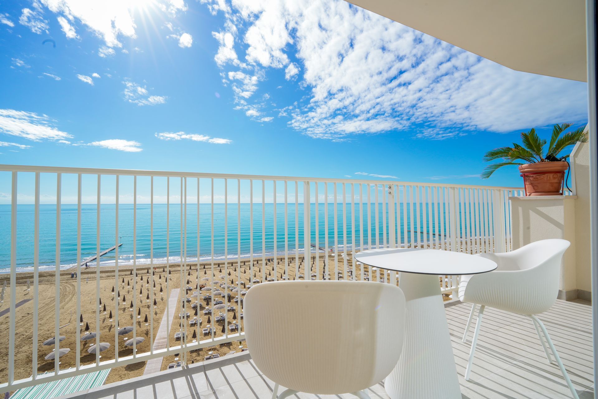 A beach filled with lots of blue and white umbrellas and chairs.