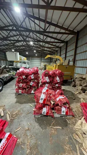 Warehouse with stacks of red bags on the floor and a yellow forklift in the background