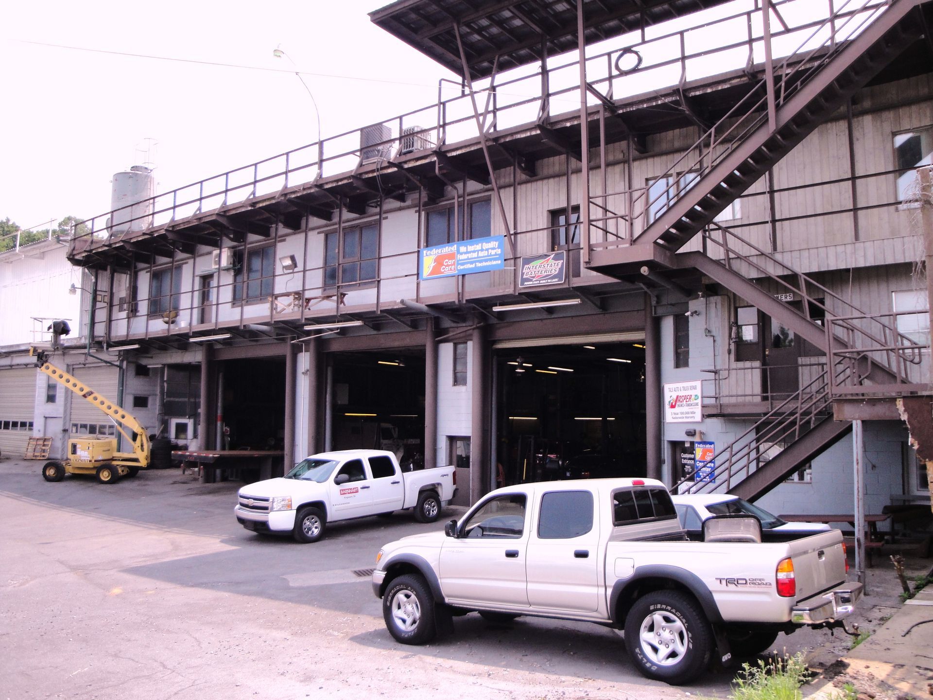 A white truck is parked in front of a building with stairs