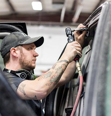 Auto Body Dent Repair — Man Fixing Car Window in Montrose, CO