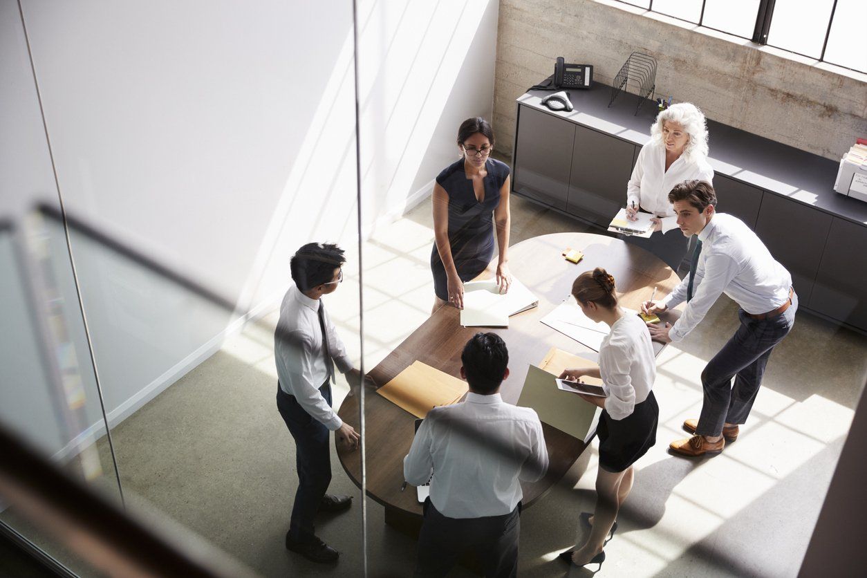 A group of people are having a meeting around a table.