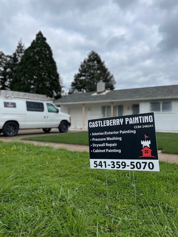 A sign for castleberry painting is in front of a house