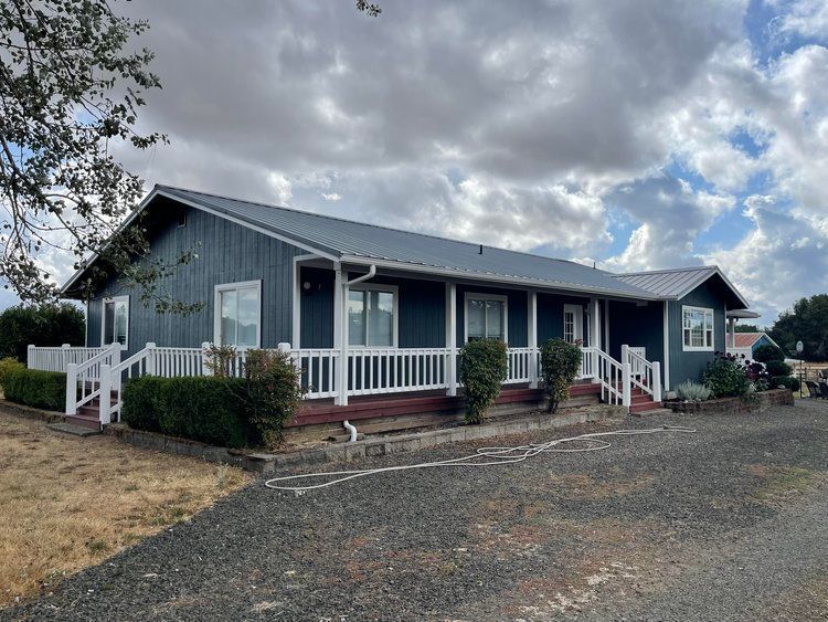 A large blue house with a white porch and stairs.