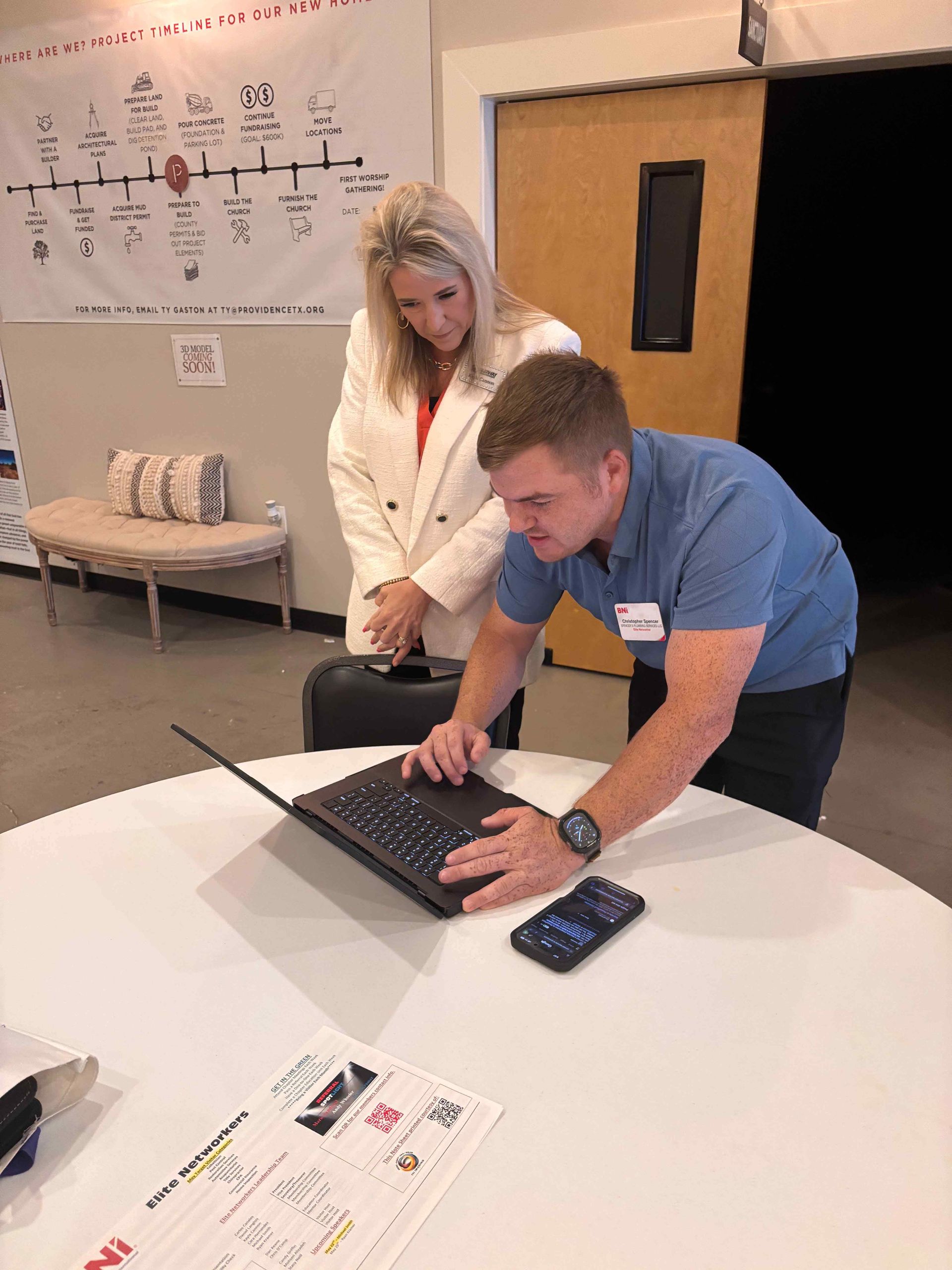 A man and a woman are looking at a laptop computer.