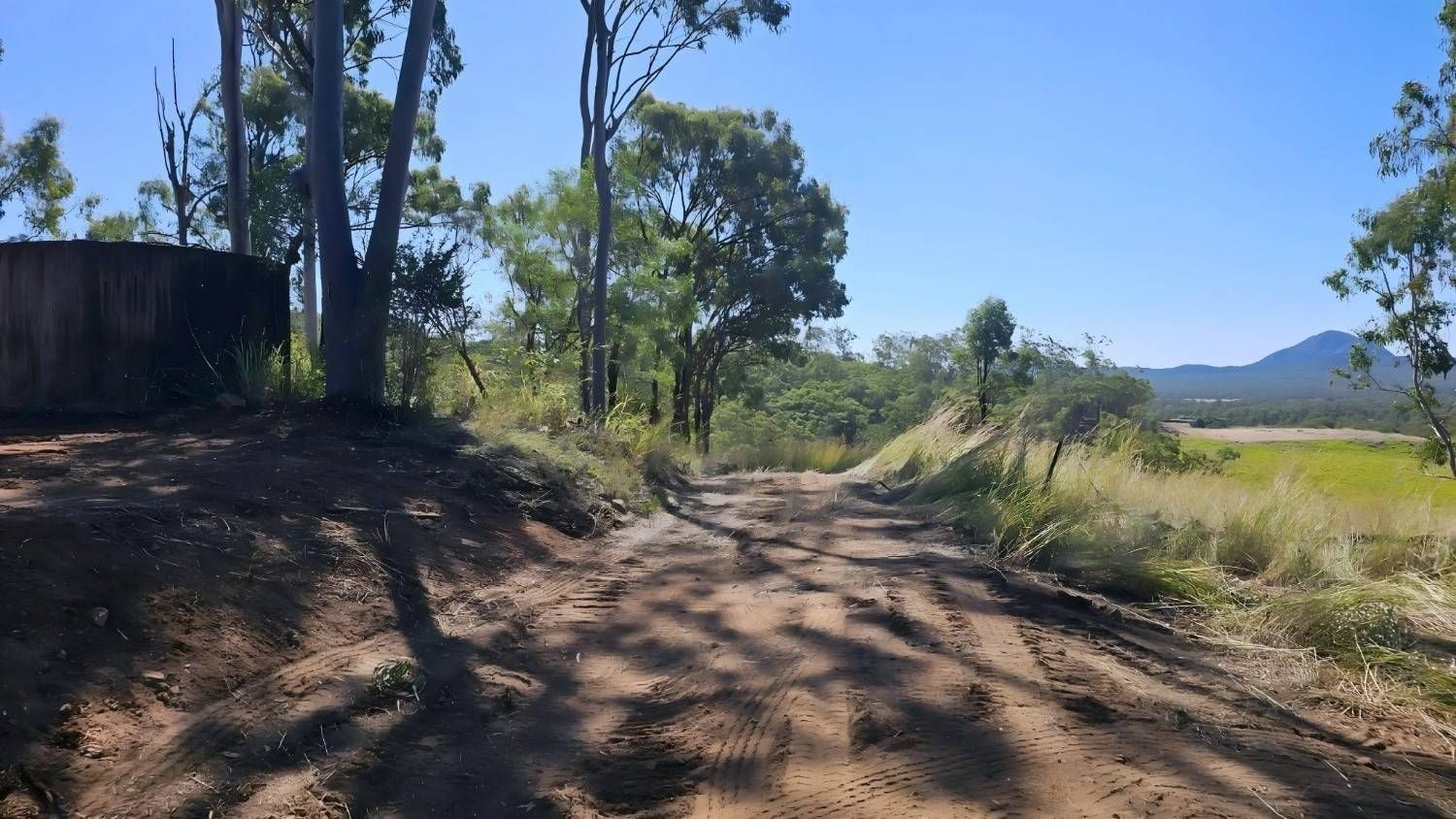 Dirt Road Through a Rural Area With Trees and a Water Tank on a Sunny Day — NPX Solutions In Yeppoon, QLD