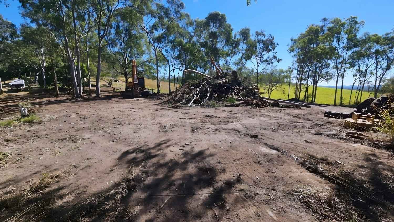 Dirt Clearing With Pile of Branches, Trees, and a Blue Sky Backdrop — NPX Solutions In Bundaberg, QLD
