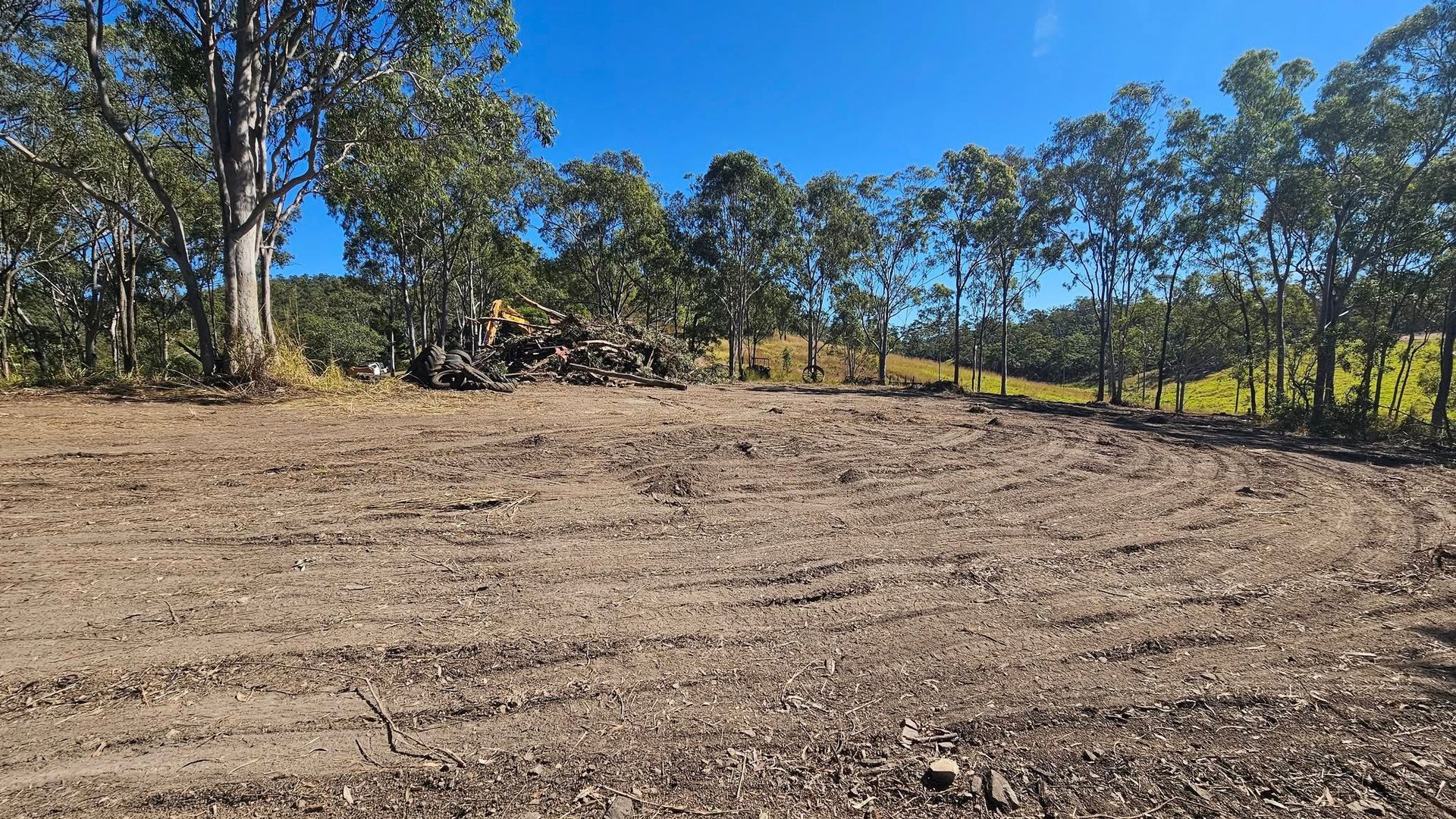Dirt Clearing With Tire Tracks, Trees in Background, and Blue Sky — NPX Solutions In Rockhampton City, QLD