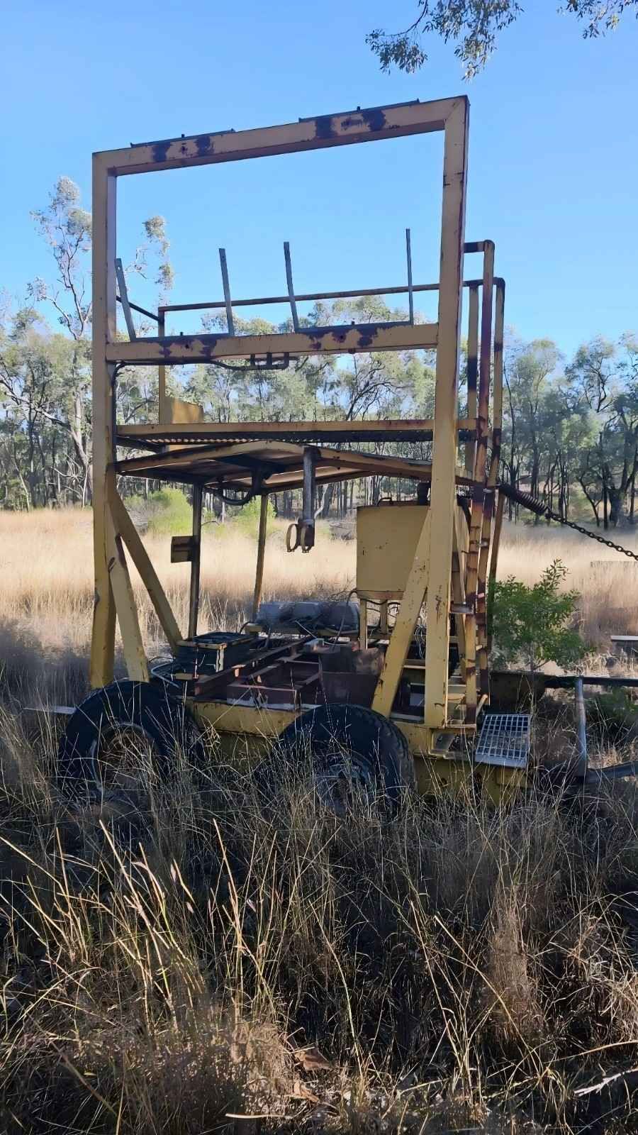 Yellow, Rusted Metal Structure in Field, Possibly an Old Farm Machine — NPX Solutions In Biloela, QLD