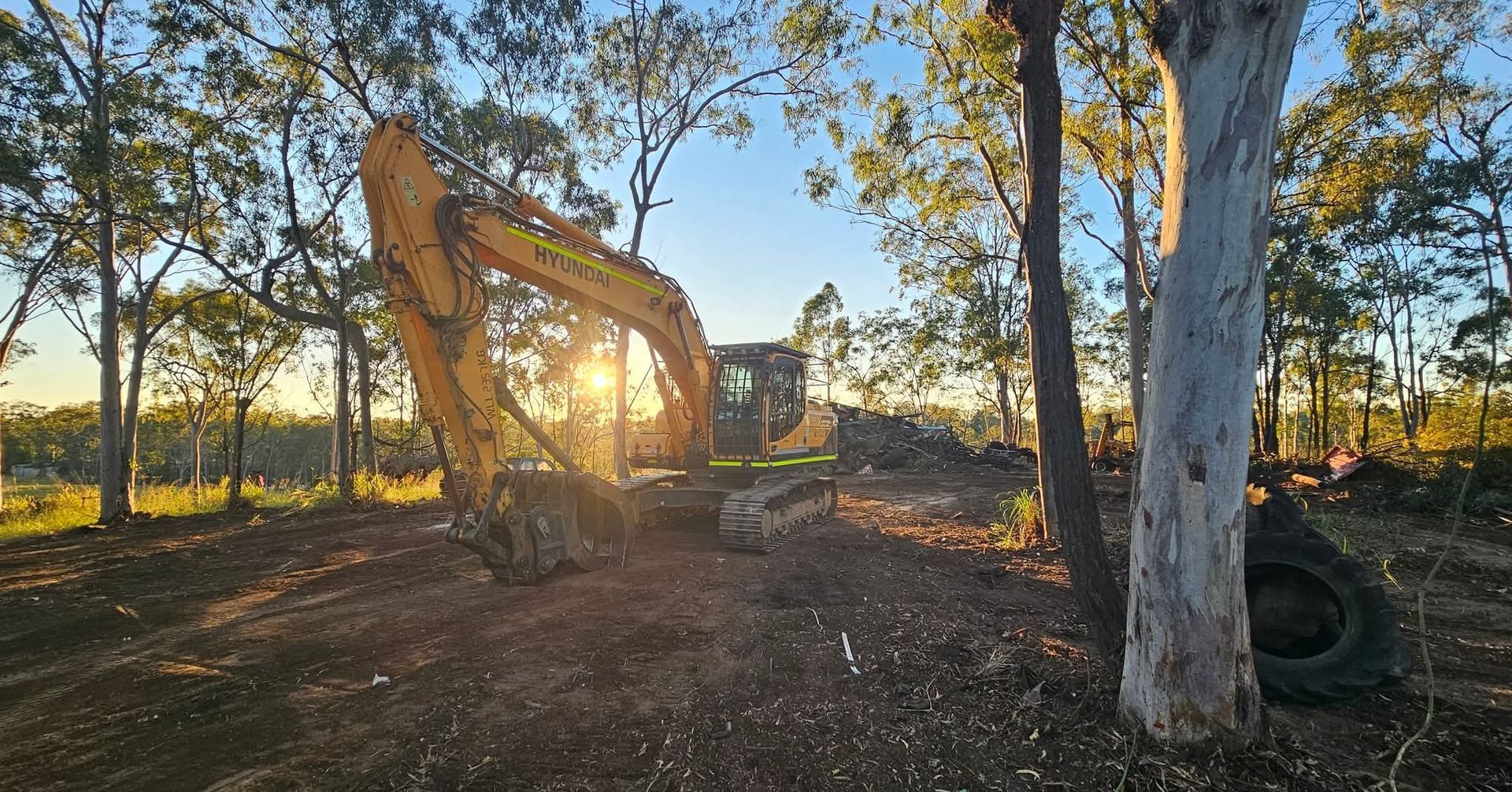 Yellow armchair next to a small table holding a vase of flowers, set on a wooden floor.