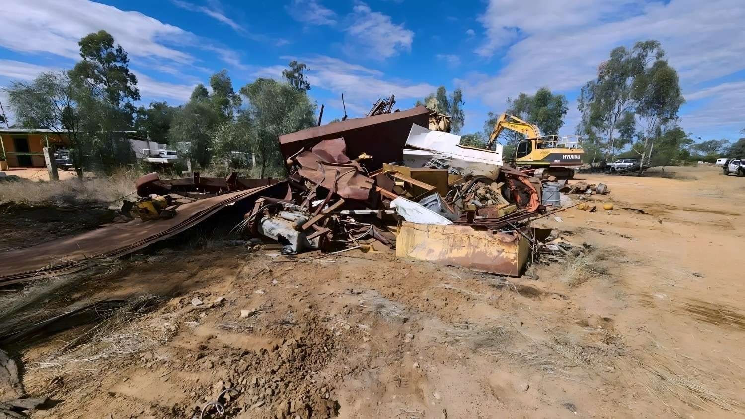 Demolition of a Building in a Rural Area With an Excavator and Debris — NPX Solutions In Clairview, QLD