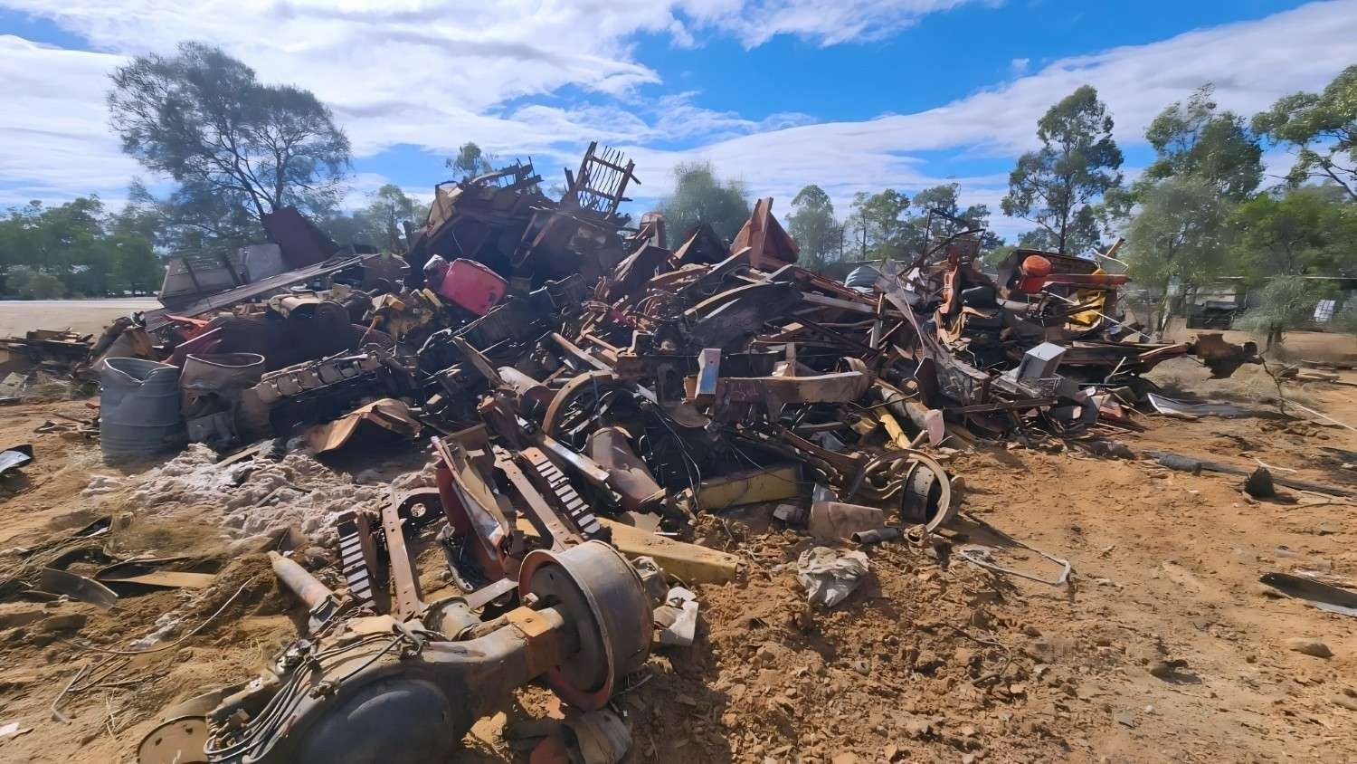 Pile of Scrap Metal in a Dry, Rural Setting Under a Partly Cloudy Sky — NPX Solutions In Emerald, QLD