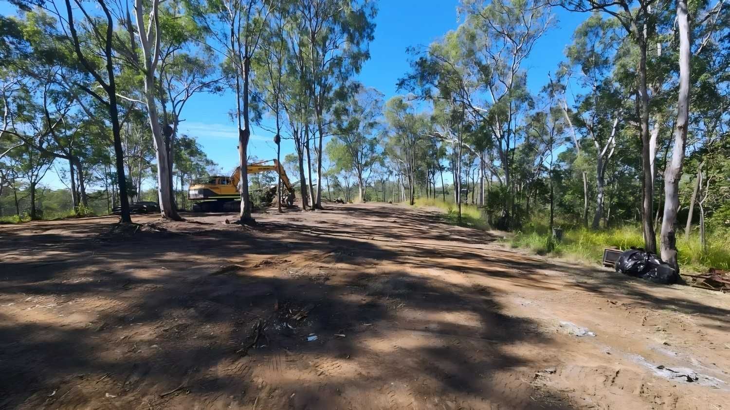 Dirt Clearing in a Wooded Area With an Excavator — NPX Solutions In Rockhampton City, QLD