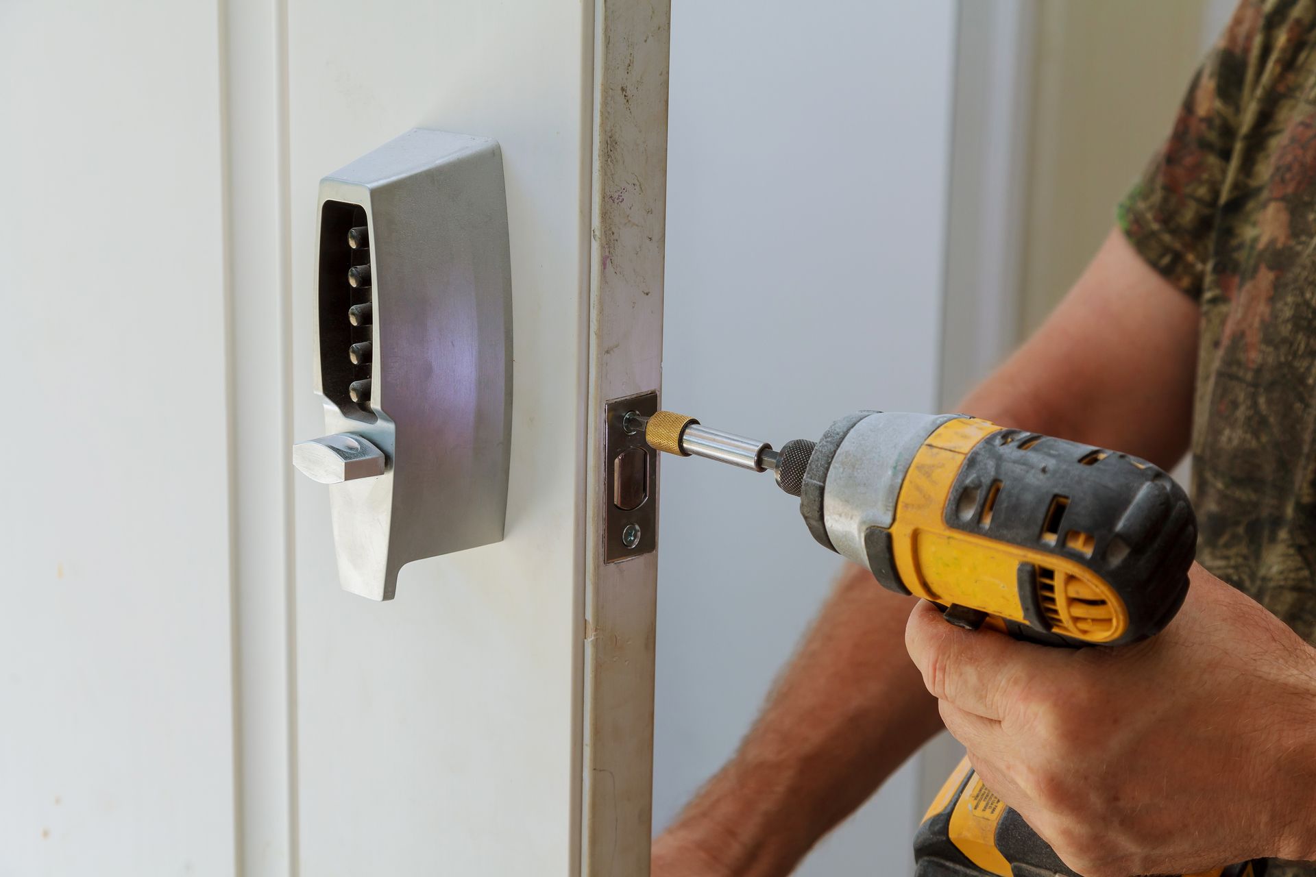 A man installing a door lock for added security.