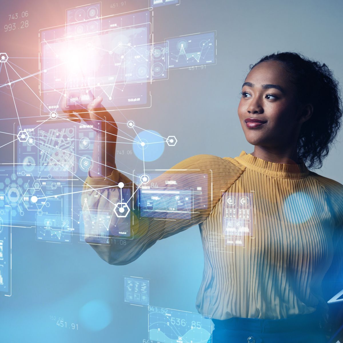 A woman is standing in front of a futuristic screen.