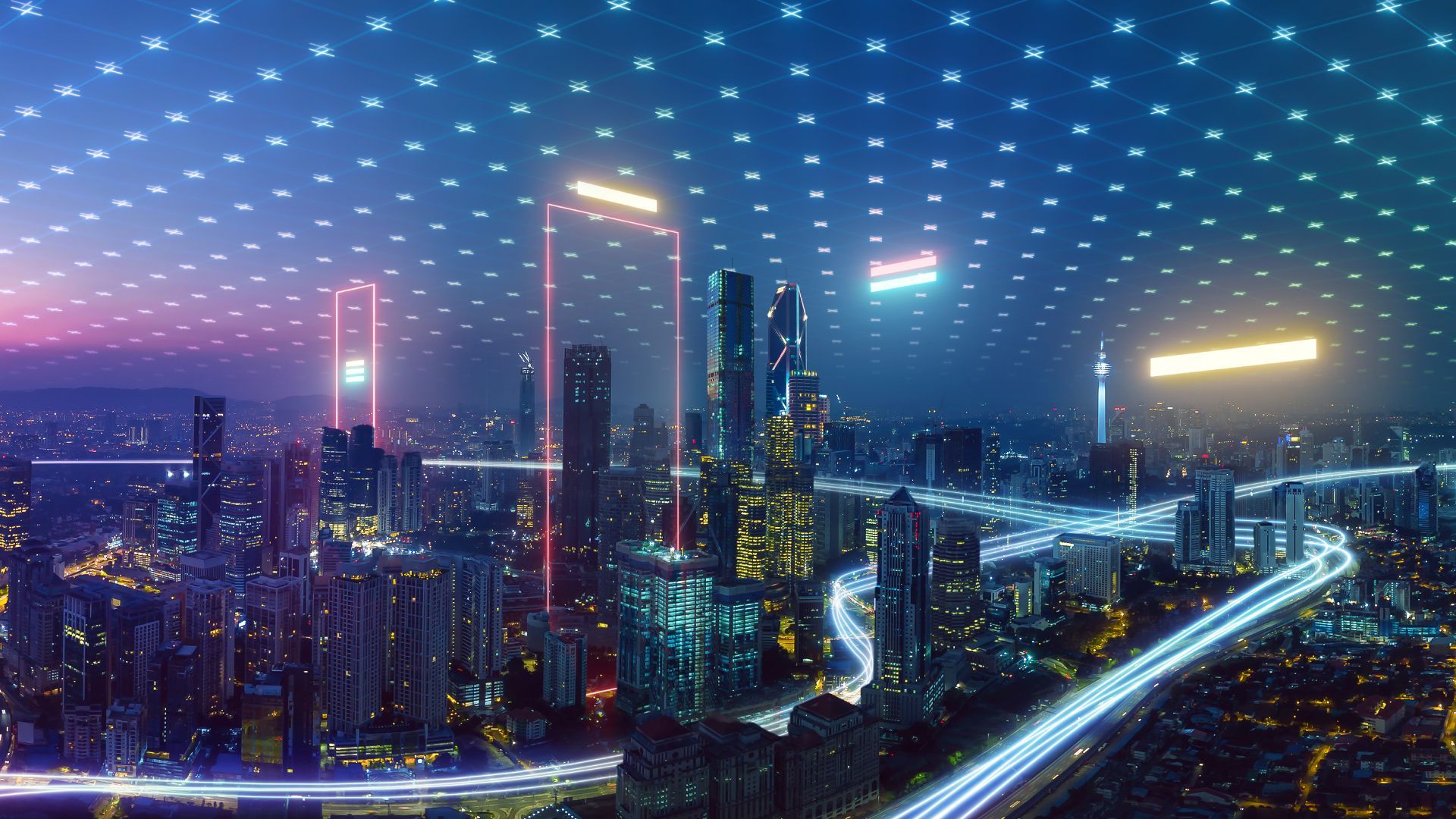 An aerial view of a futuristic city at night with neon lights.