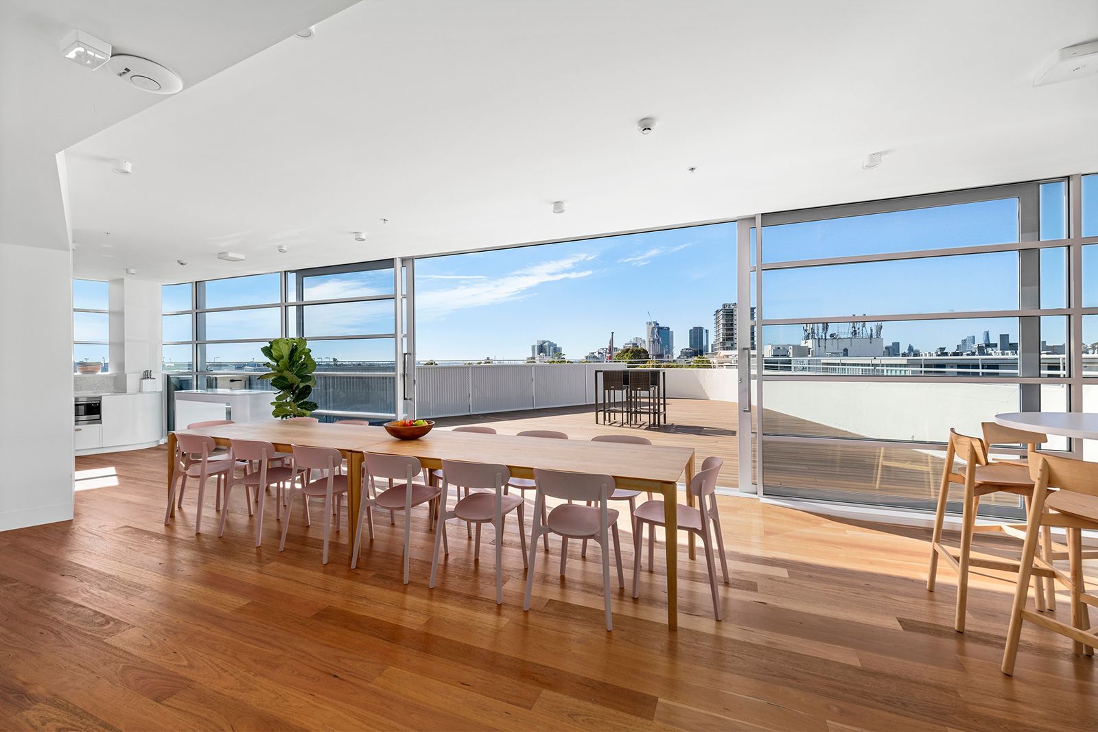 A large dining room with a table and chairs and a view of the city.