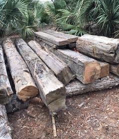 a pile of logs sitting on top of each other on the ground .
