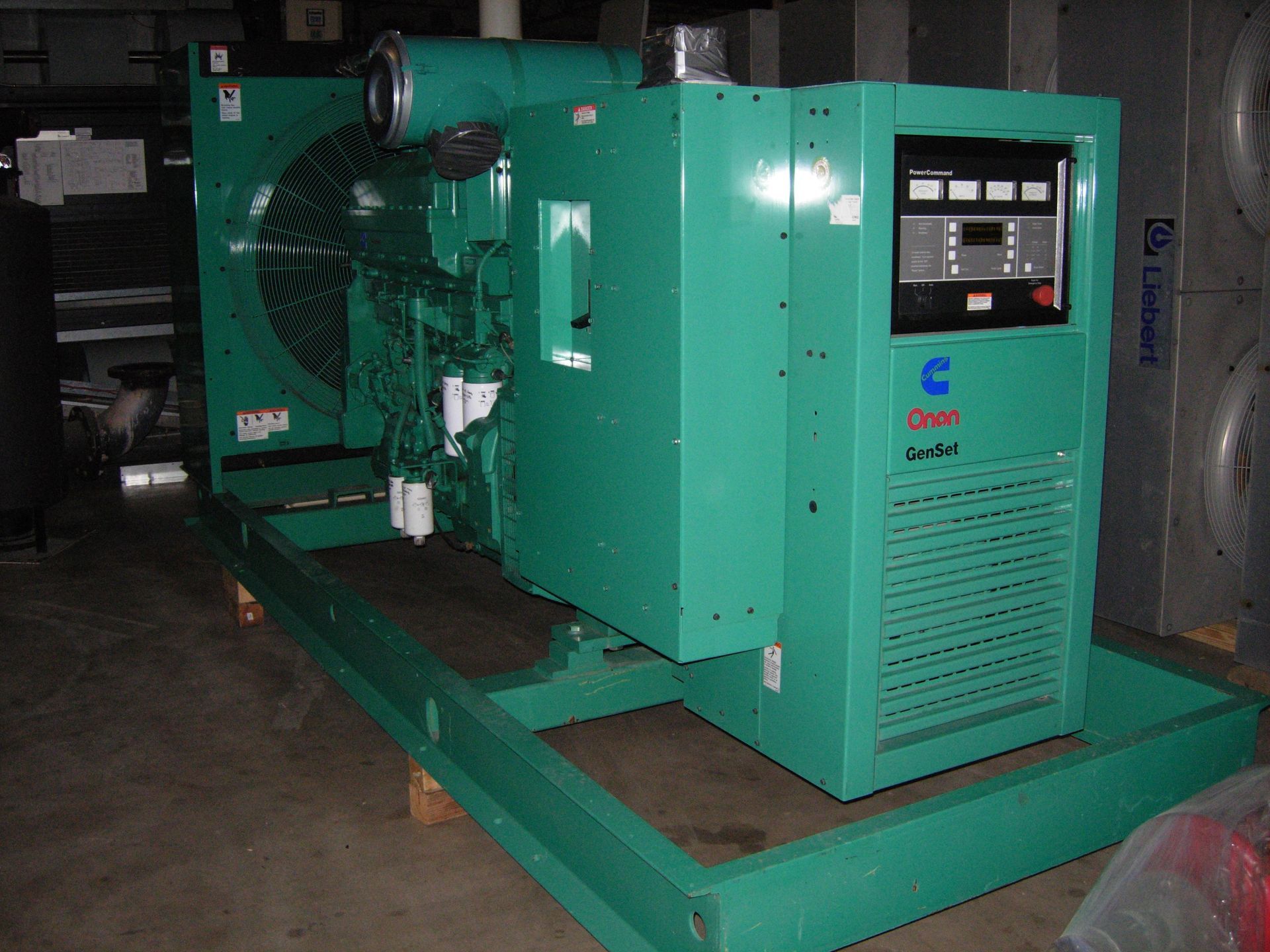 Green Cummins diesel generator on a green frame in a commercial setting.