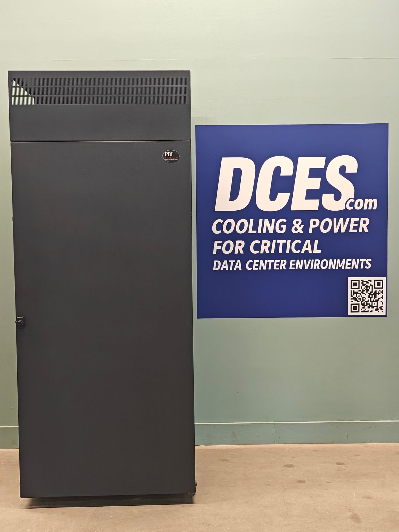 Dark gray server rack next to a blue sign reading 