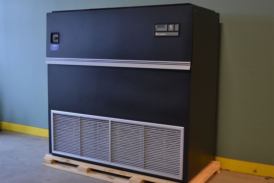 A black box is sitting on a wooden pallet in a room.