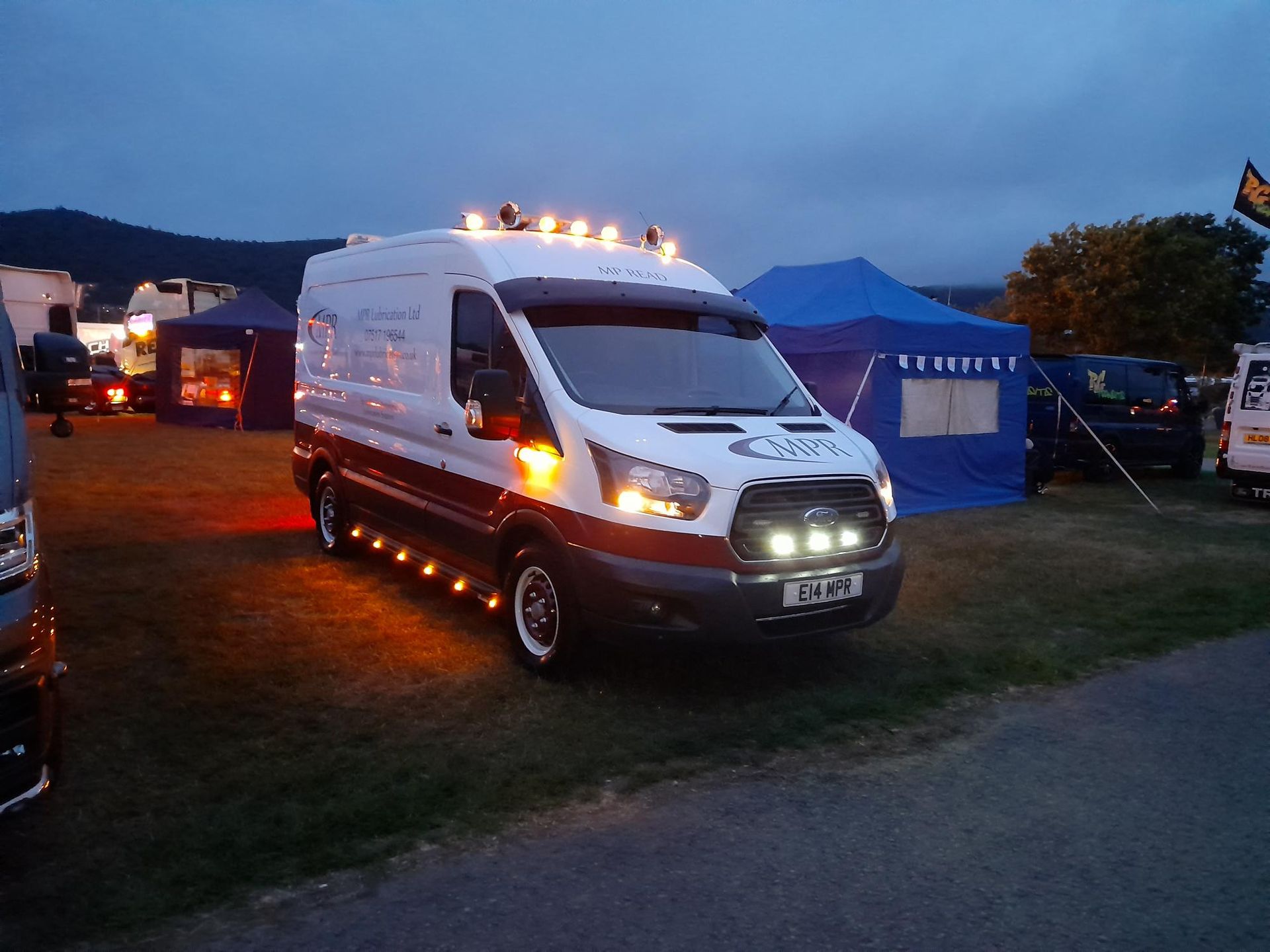 transit ford mk2 l2h2 van 2014 signwritten MPR at dusk, truckfest 2023 with lights on, airhorns on roof and la lightbars on sidebars