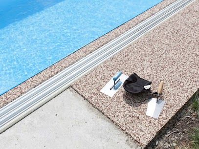 Two Trowel And A Bag Are Sitting On A Concrete Surface Next To A Swimming Pool — River2Coast Concreting in Boambee, NSW