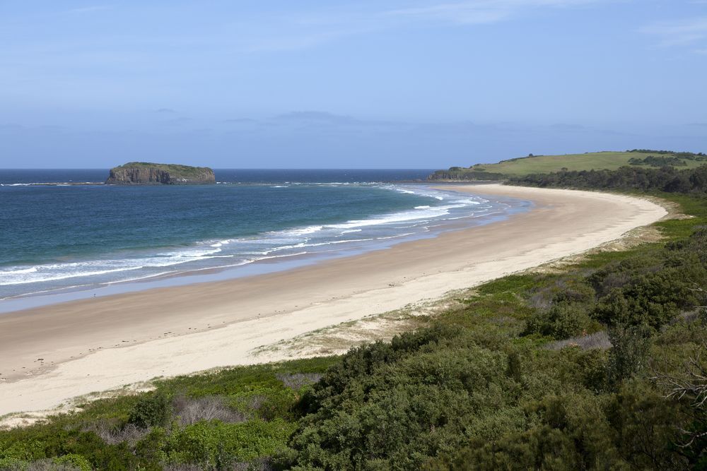 A Long Beach With A Small Island In The Distance  — River2Coast Concreting in Boambee, NSW