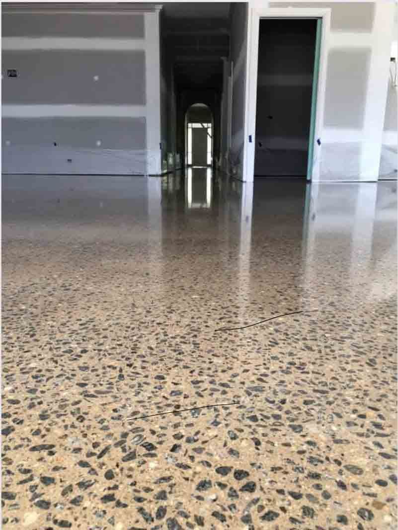 A Shiny Concrete Floor In A Room With A Door In The Background  — River2Coast Concreting in Coffs Harbour, NSW