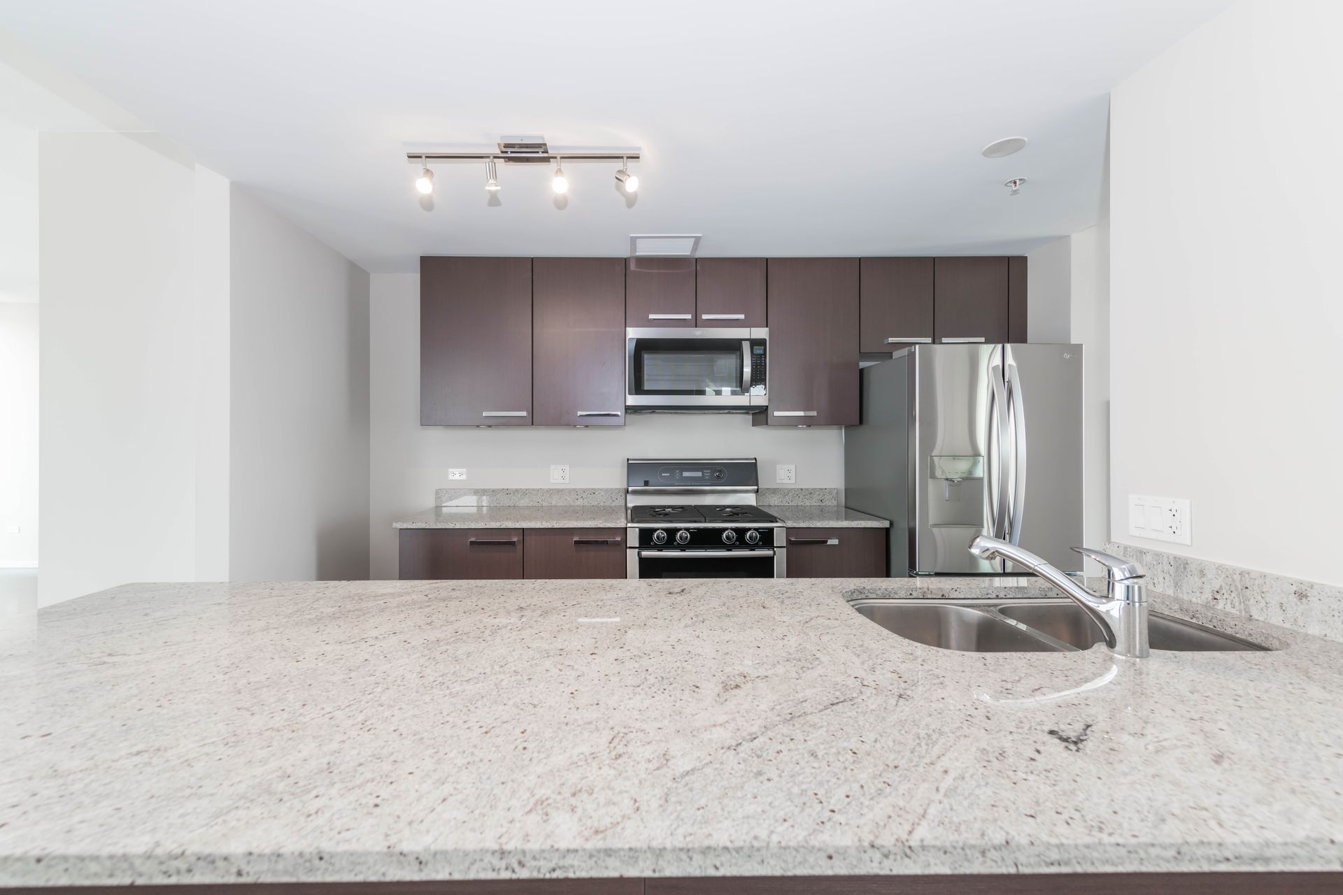 A kitchen with granite counter tops and stainless steel appliances at 24 S Morgan Apartments.