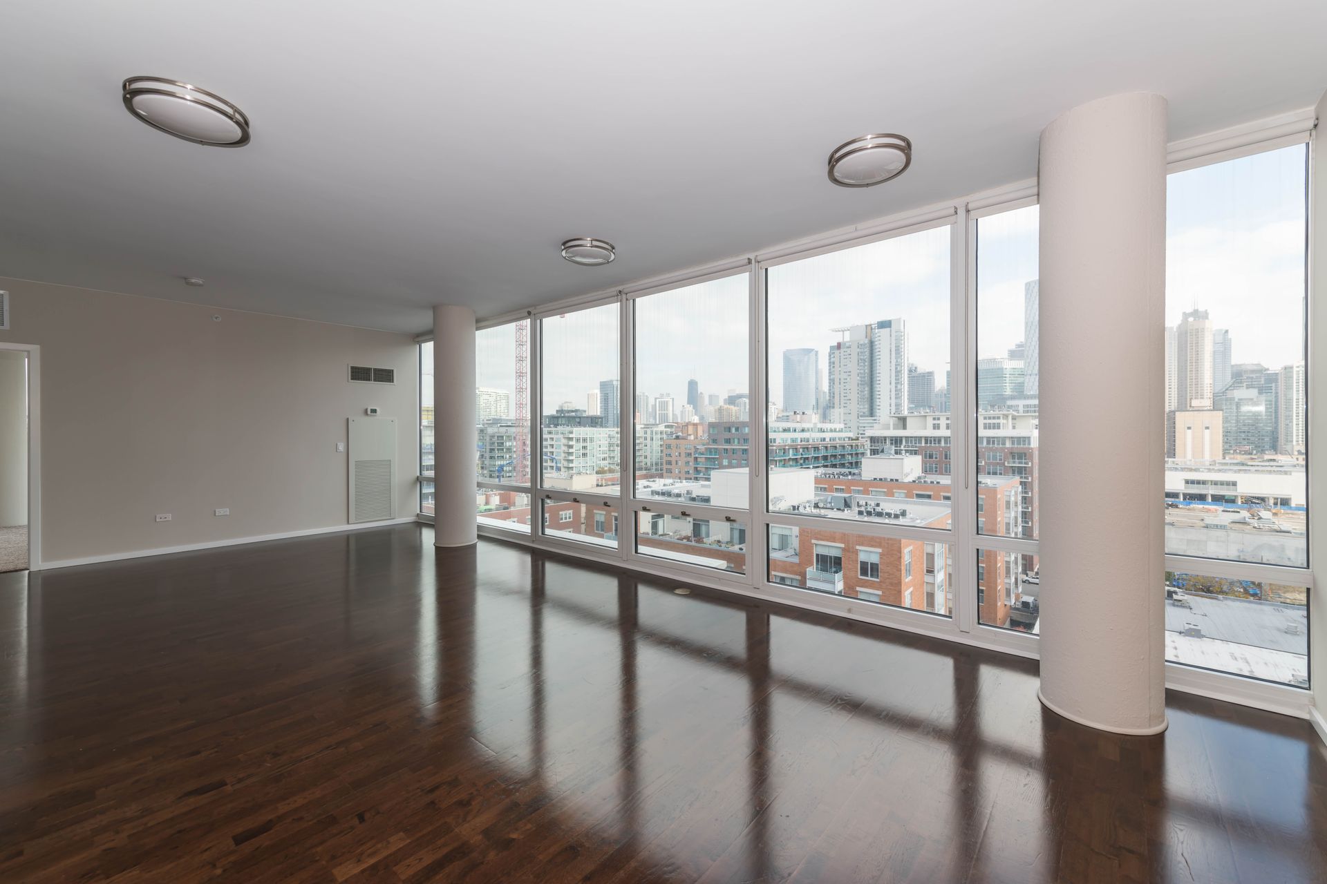 An empty apartment with lots of windows and a view of the city at 24 S Morgan Apartments.