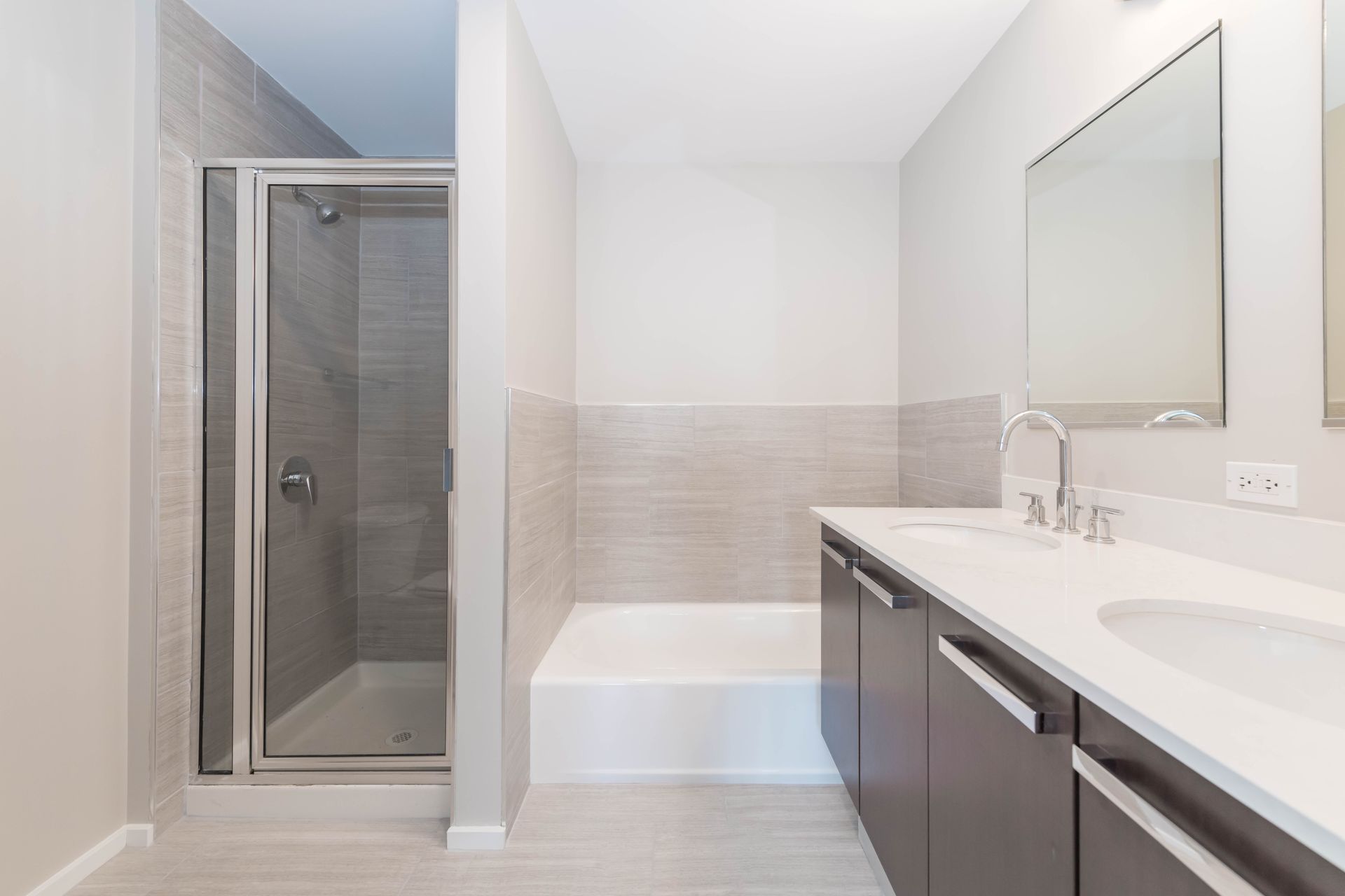 A bathroom with a sink , tub , shower and mirror at 24 S Morgan Apartments.