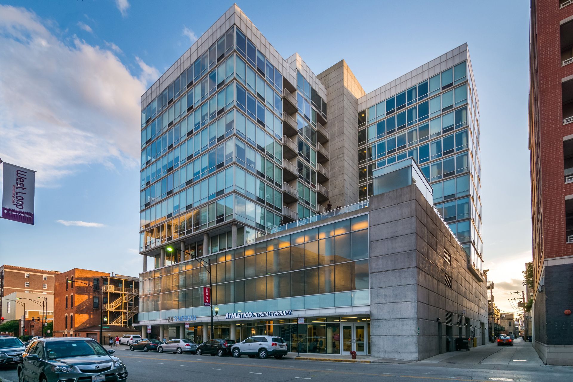 A modern glass building with a sign that reads