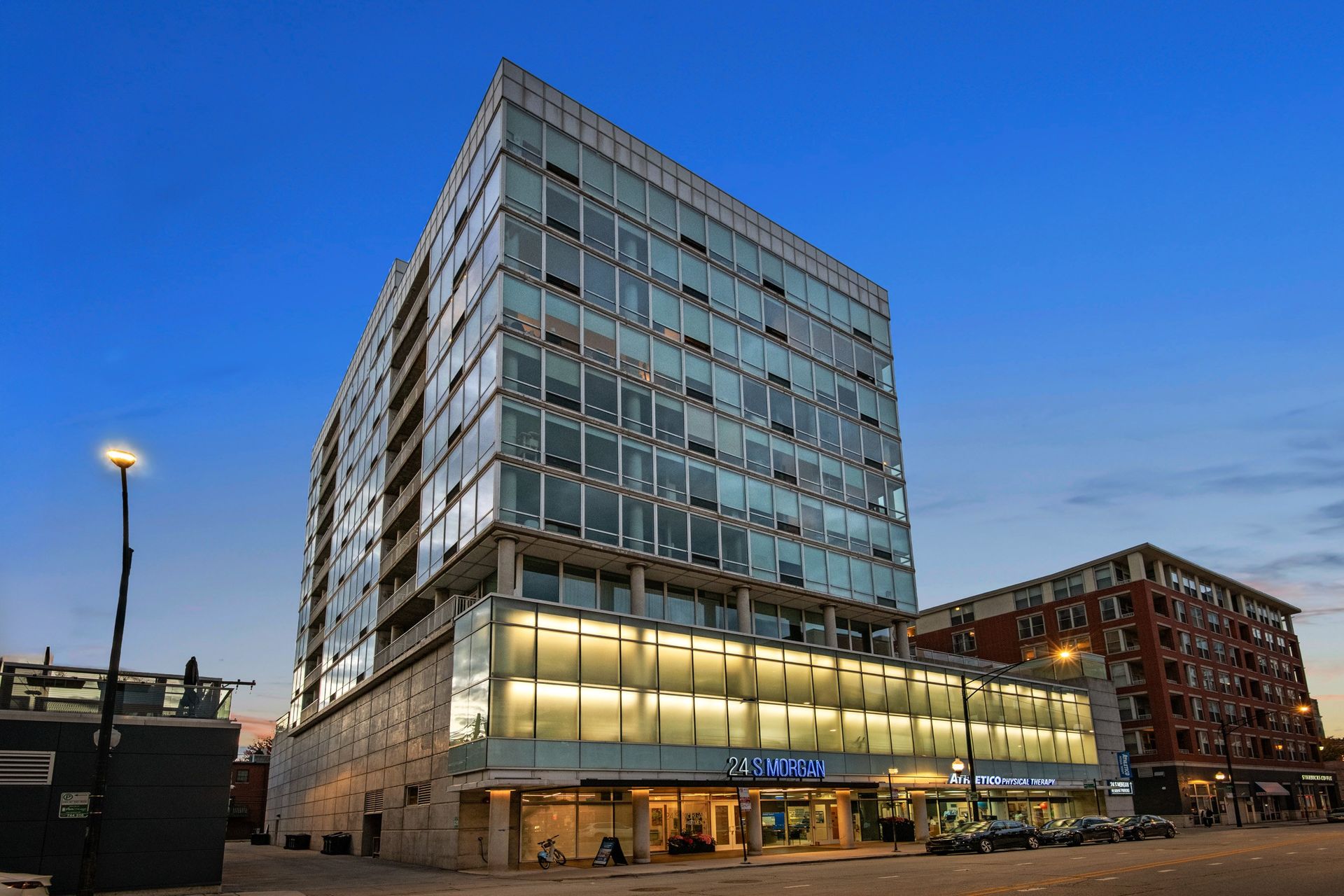 A modern glass building with the sign 24 MIRAN on the ground floor.