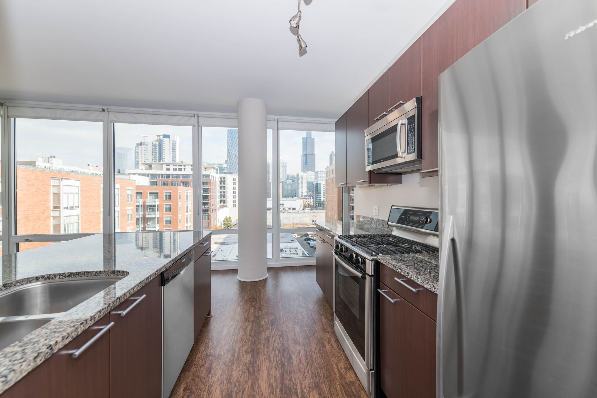 A kitchen with stainless steel appliances and granite counter tops at 24 S Morgan Apartments.