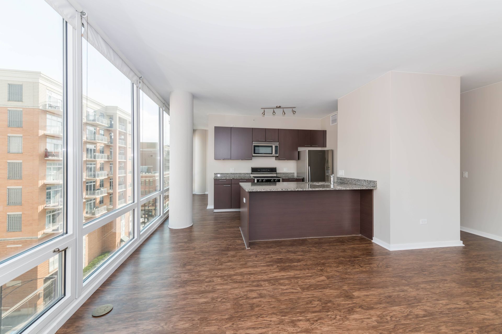 a living room with a large window and a kitchen