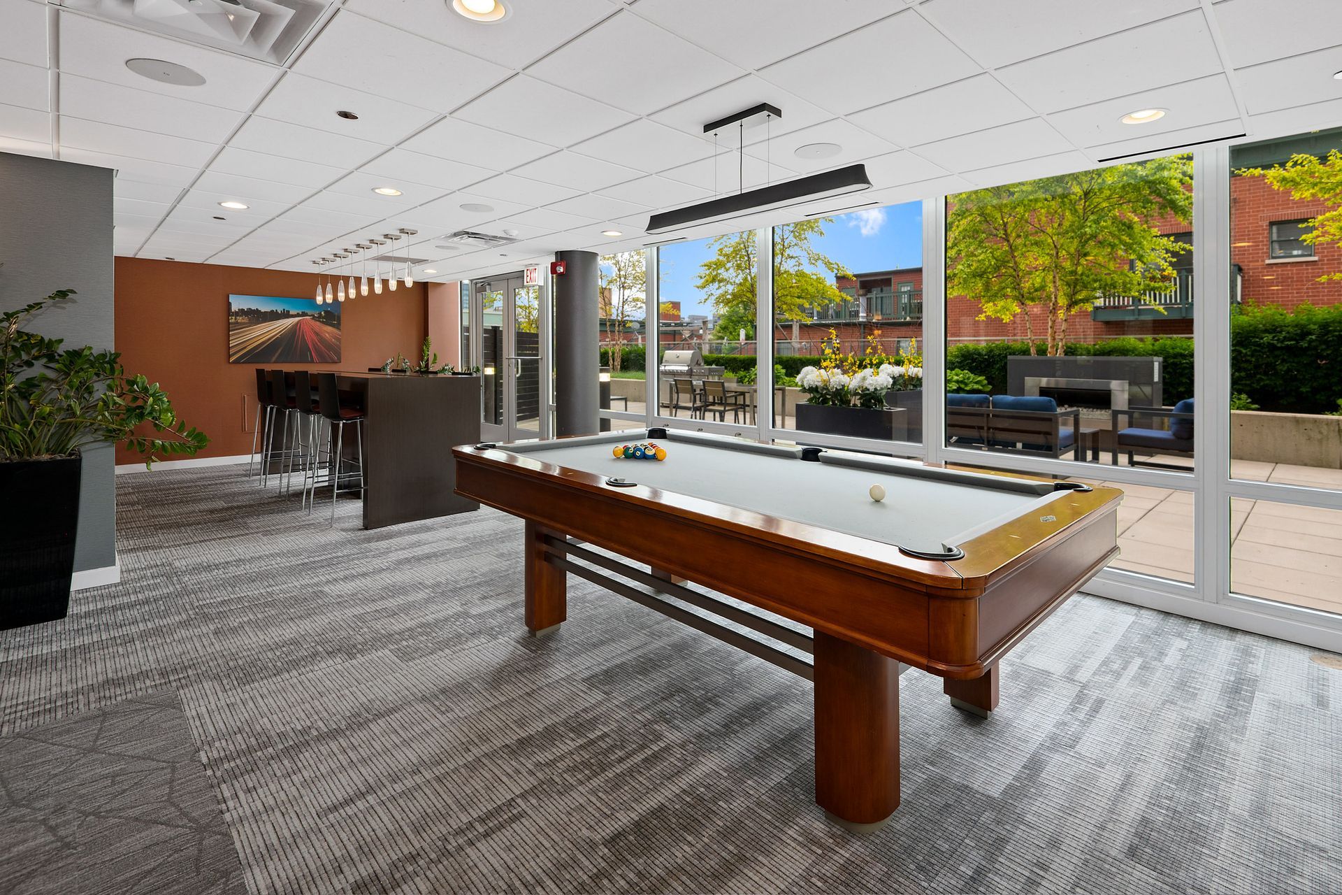 A pool table in a room with a lot of windows at 24 S Morgan Apartments.