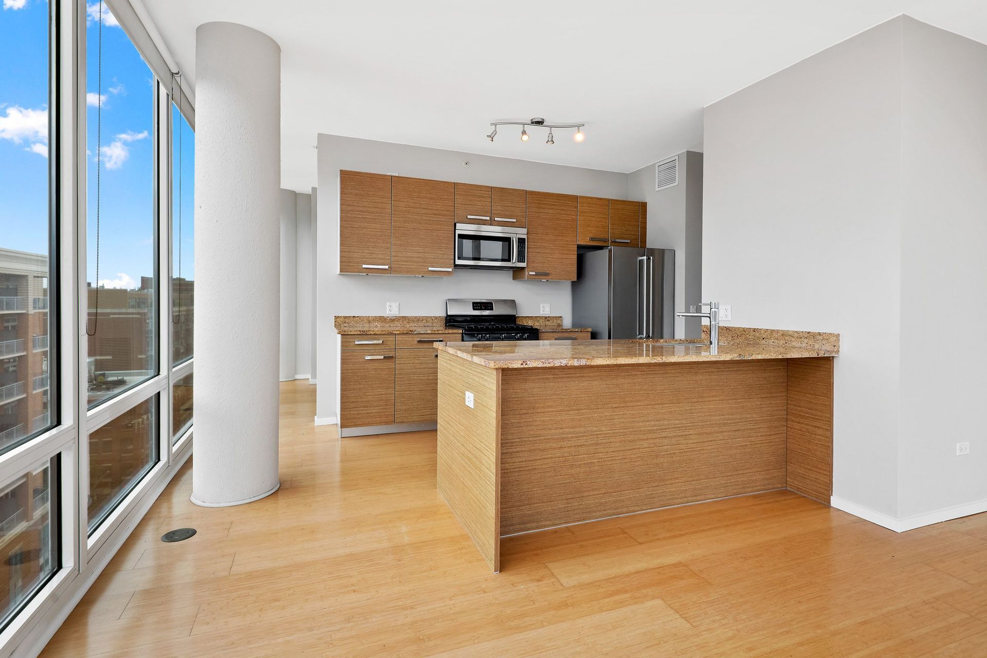 a kitchen with wooden cabinets and a large window